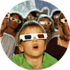 small kid surrounded by people all wearing 3D glasses watching a 3D movie at our Skylon Theatre